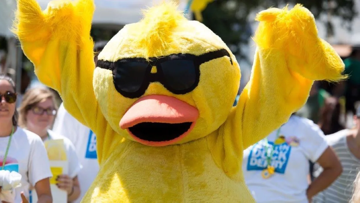 Quacky the duck mascot cheering at a duck race.