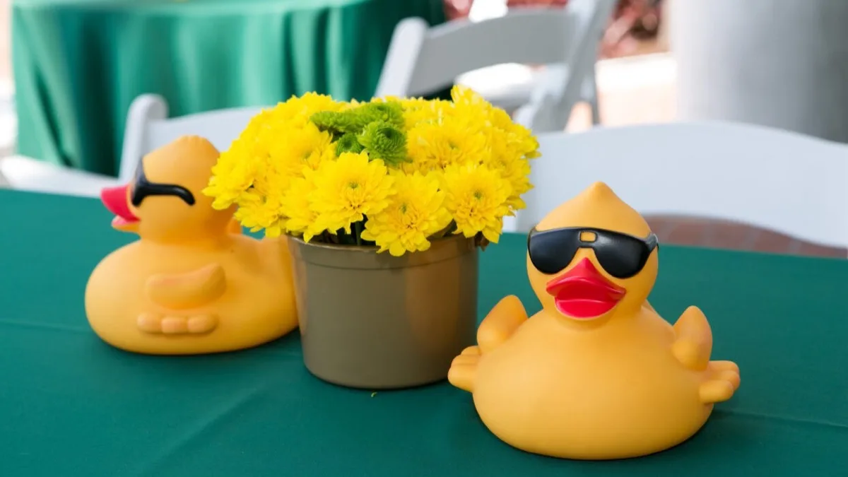 Corporate-branded rubber ducks lined up on a table.