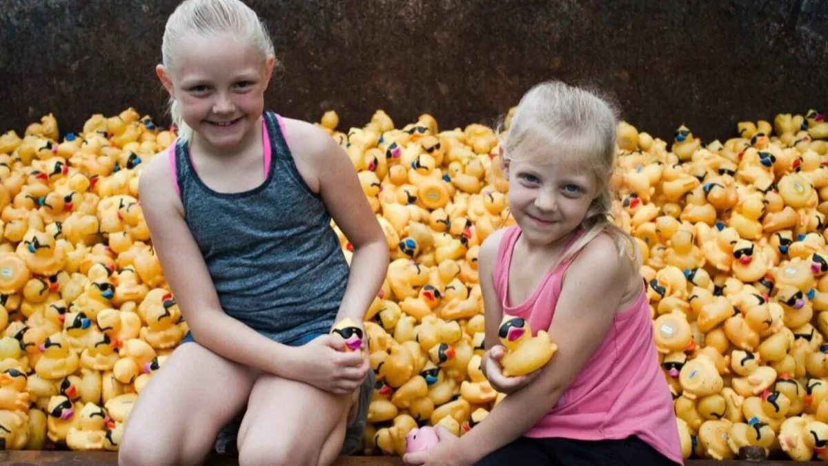 Kids holding rubber ducks at a community duck race.