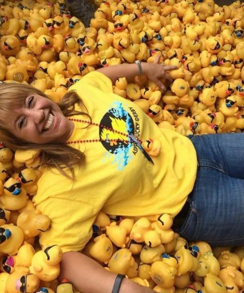 A supporter lies happily among thousands of rubber ducks.
