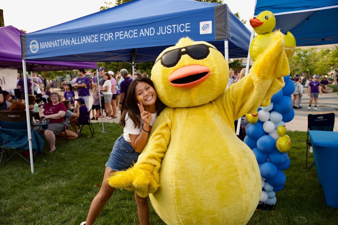 The Derby Duck mascot shares a hug at a community duck race.